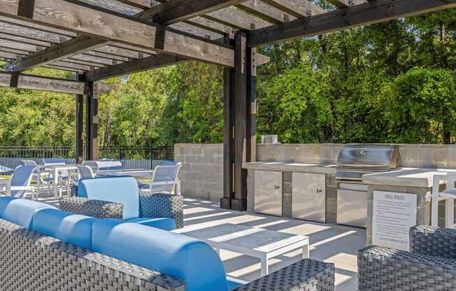 a swimming pool with a wall of plants and a blue water feature at The Lorient Apartments, Florida, 32514