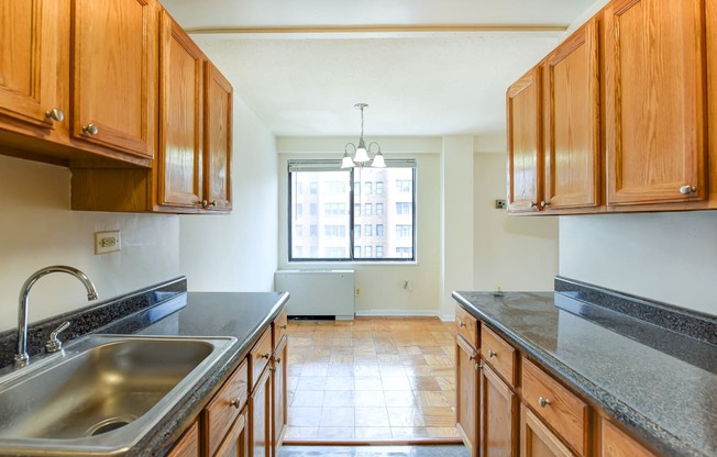 kitchen with wood cabinetry and view of dining area at twin oaks apartments in columbia heights washington dc