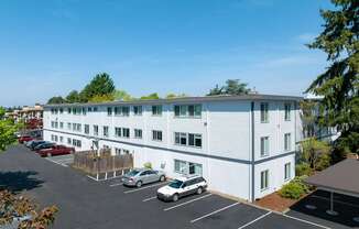 A white building with a parking lot in front of it.