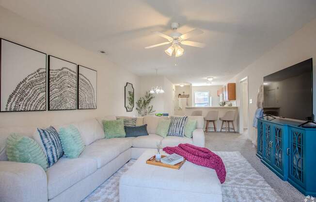 A living room with a white couch and a ceiling fan.