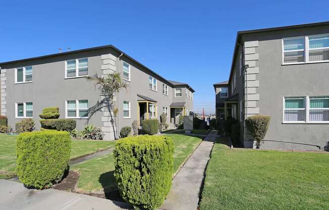 A row of houses with green bushes in front.