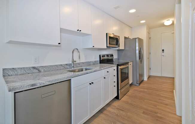 a renovated kitchen with white cabinets and stainless steel appliances