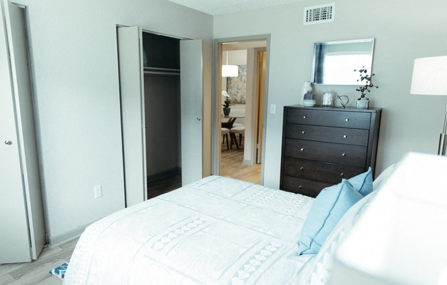 a bedroom with a bed and a dresser and a mirror