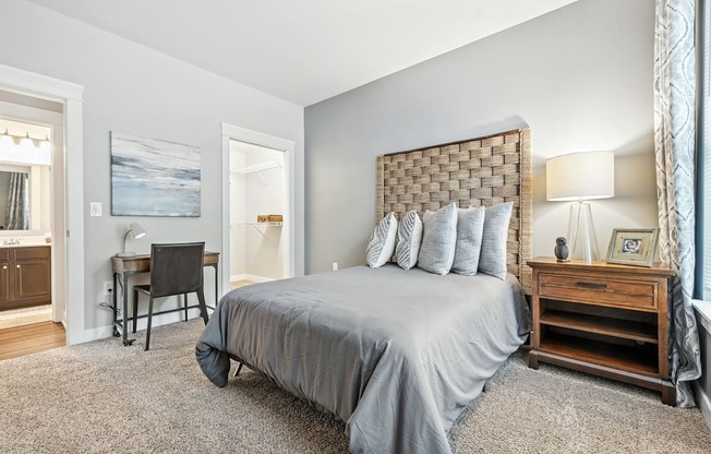 A bedroom with a large bed and a desk.