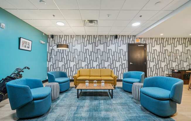 a waiting room with blue chairs and a yellow couch