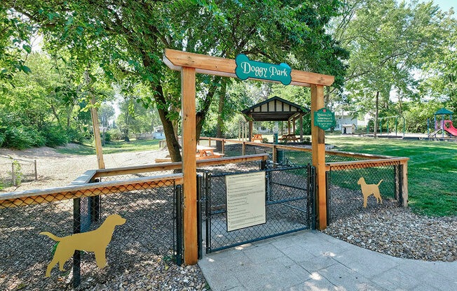 a dog park with a gate and dogs walking through it