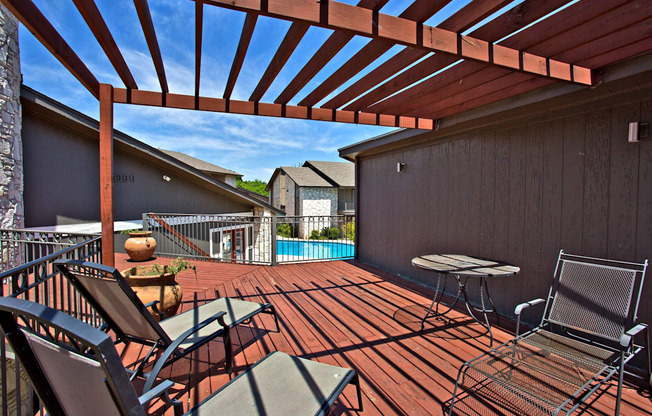 a covered deck with a pool and patio furniture