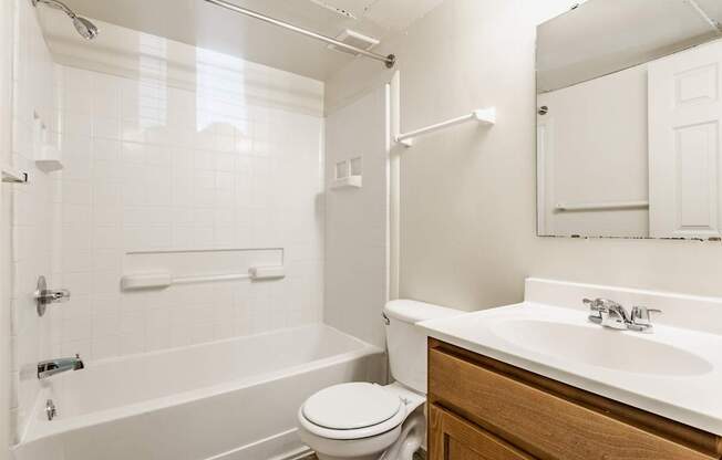 A white bathroom with a toilet, sink, and bathtub