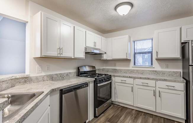 A kitchen with white cabinets and stainless steel appliances.