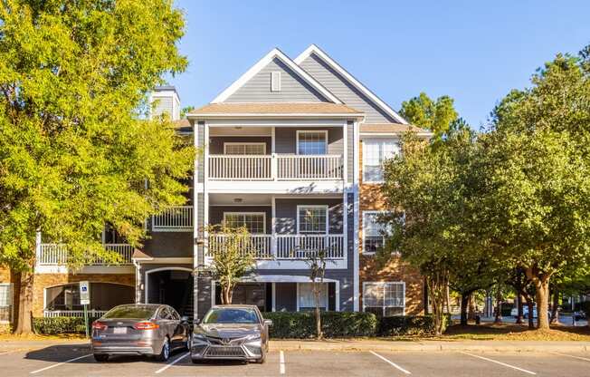 an apartment building with two cars parked in front of it