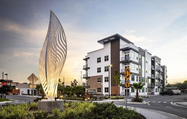 a building with a sculpture in front of it near a street