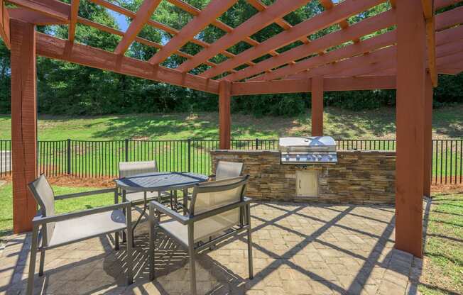 A patio with a table and chairs under a pergola.at Spring Creek Apartments, Florida, 32536