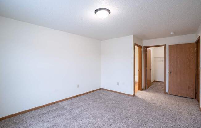 A room with a carpeted floor and a ceiling light. Fargo, ND Park Place Apartments