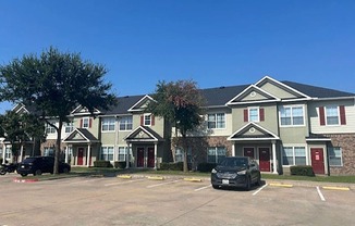 an empty parking lot in front of an apartment building