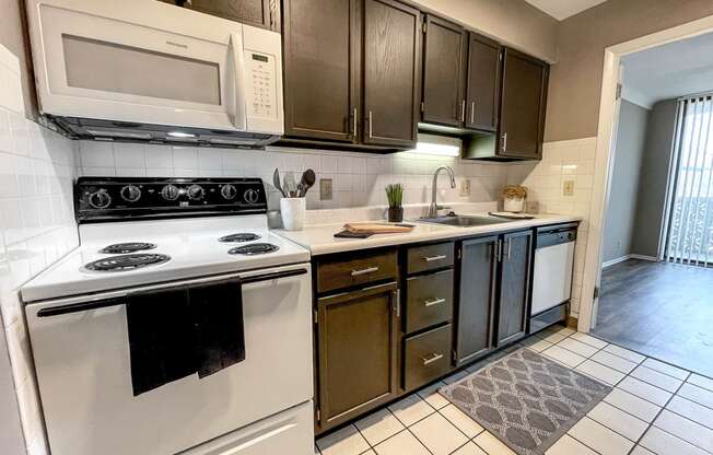 A kitchen with white appliances and black cabinets.