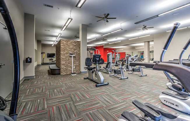 A gym with a variety of exercise equipment including treadmills, elliptical machines, and weights at Highland Row Apartments, TN, 38111