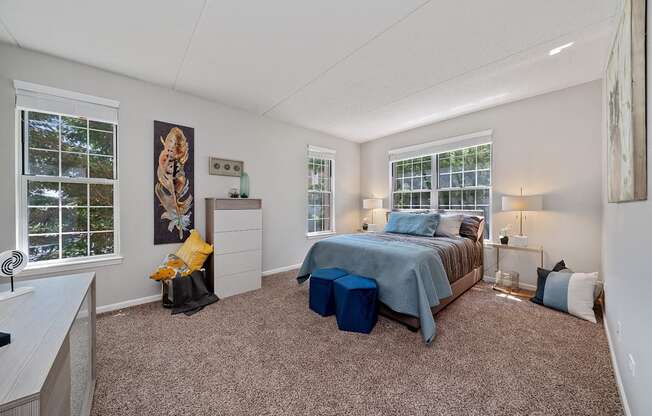A bedroom with a bed, nightstand, and window.