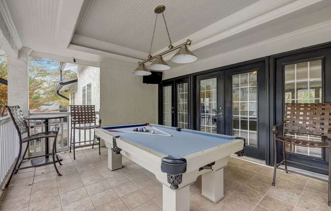 a pool table in the porch of a house with a patio