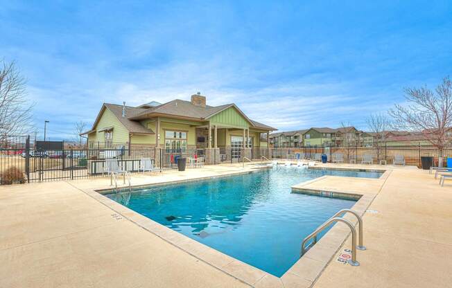a swimming pool with a house in the background