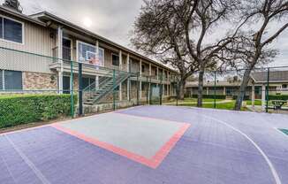 a basketball court in front of a building with stairs