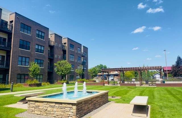 a fountain in the middle of a park with a building