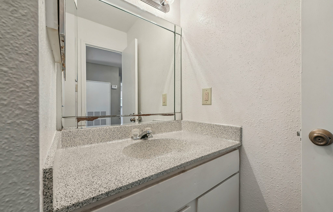 Bathroom vanity with a sleek countertop at Driscoll Place Apartments.