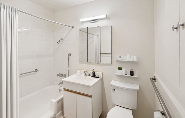 Model Bathroom with White Cabinets, Wood-Style Flooring & Shower/Tub at Walnut Creek Apartments located in Walnut Creek, CA.