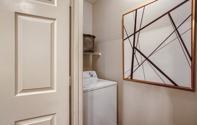 a small closet with a mirror and a washer and dryer in a bathroom