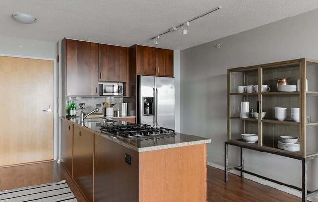 A modern kitchen with a wooden island and stainless steel appliances.