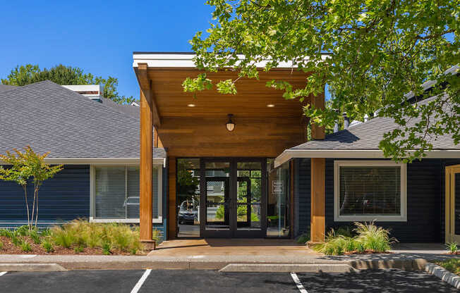 A modern house with a black roof and a wooden entrance.