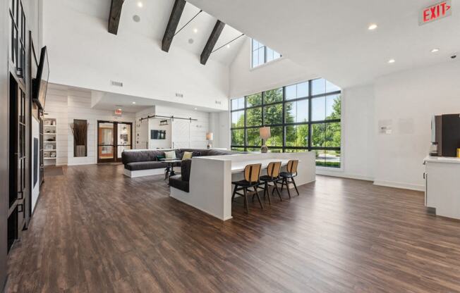 a living room with a kitchen and a dining area with a large window