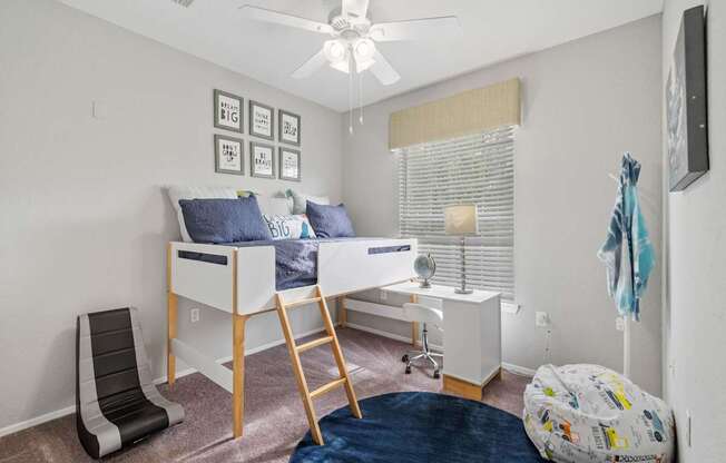 A room with a bunk bed and a chair.