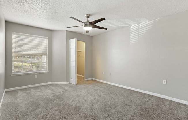 Model bedroom with carpeted floor and a ceiling fan at Hunters Green in Tampa, Florida.