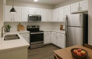 A kitchen with white cabinets and a stainless steel refrigerator.