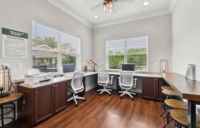 A well-lit office space with a desk, chairs, and a printer.
