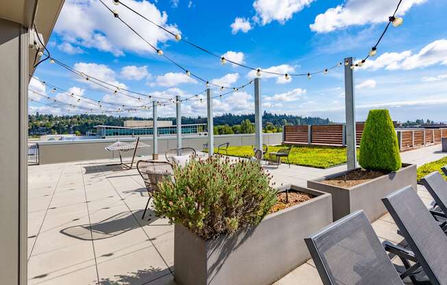 A patio with a table and chairs and a planter box.