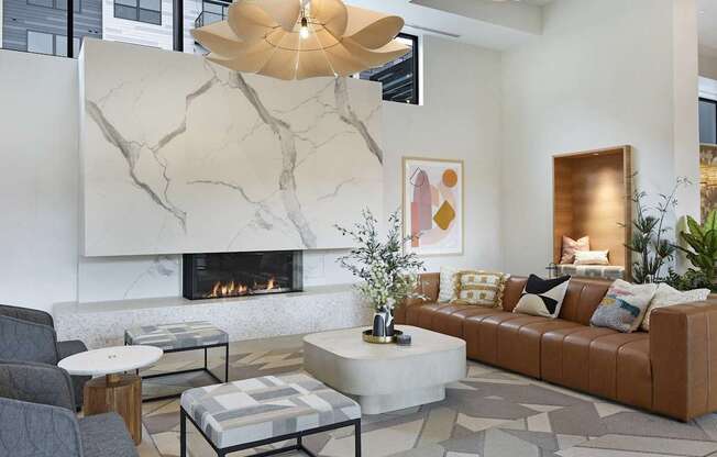 A modern living room with a fireplace and a grey sofa.