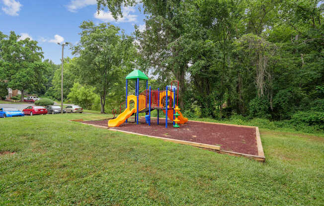 A playground with a yellow slide and a green roof.