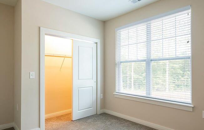 a bedroom with a large window and a closet  at Sapphire at Centerpointe, Midlothian, VA