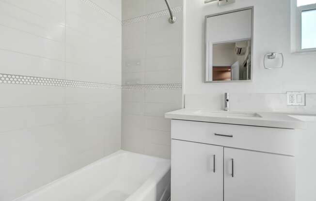 a bathroom with a sink and a bath tub and a mirror