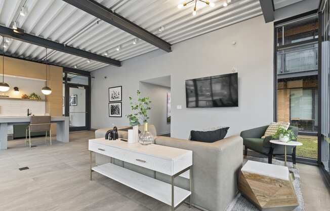 a living room with a couch coffee table and a tv on the wall