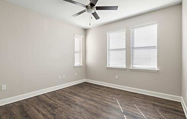 an empty living room with wood floors and a ceiling fan at The Verandah, Austin, TX