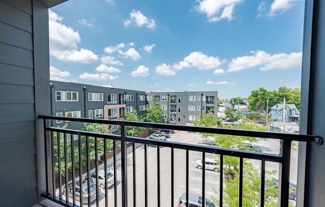 A balcony view of a residential area with cars and buildings.