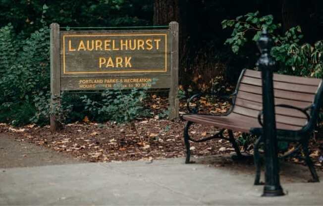 a park bench sitting in front of a park sign