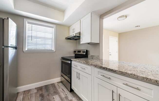 a kitchen with white cabinets and a granite counter top