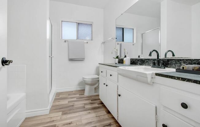 a bathroom with white cabinets and a sink and a toilet