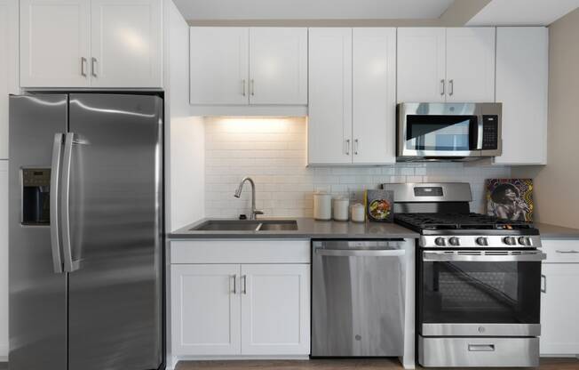 a kitchen with stainless steel appliances and white cabinets