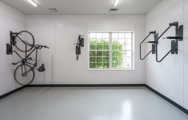 a large white room with a large window and several bikes hanging on the wall