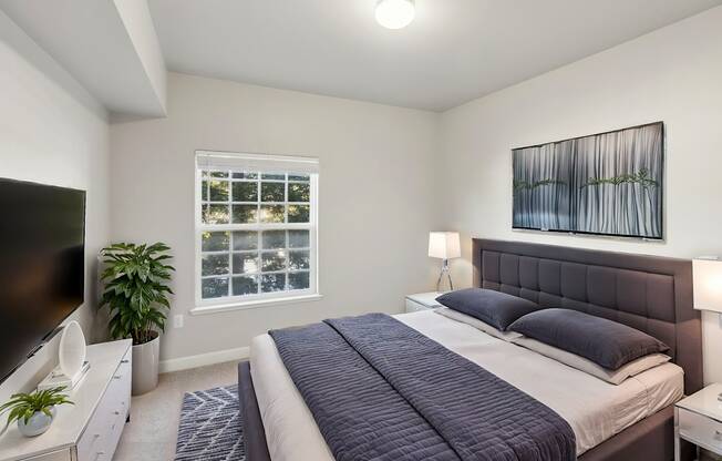 A bedroom with a large bed and a television.