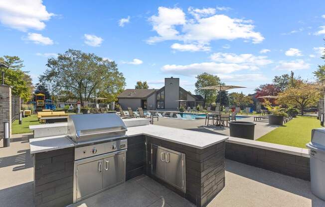 a patio with an outdoor kitchen and a swimming pool